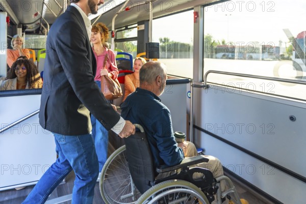 Man supporting a passenger in a wheelchair, providing assistance while boarding public transport, showing social inclusion and accessibility inside a modern bus with other diverse people