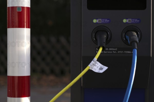 Detailed view, parking lot with gas pump, EnBW charging station for electric cars, charging station, e-charging station, e-mobility, charging cable leading into two vehicles, Stuttgart, Baden-Württemberg, Germany