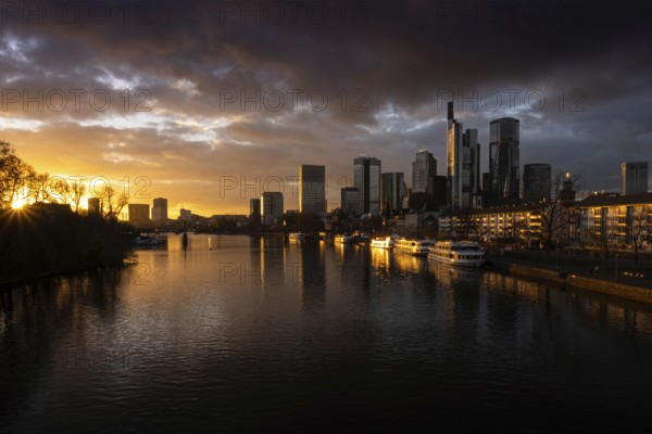The sun sets behind the Main and bathes Frankfurt's banking skyline in orange-yellow light, Alte Brücke, Frankfurt am Main, Hesse, Germany