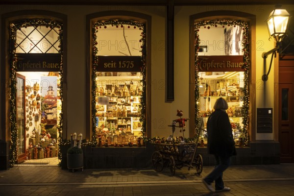 At Christmas time, a passerby strolls through Frankfurt's New Old Town and looks at the shop windows of a souvenir shop, Neue Altstadt, Frankfurt am Main, Hesse, Germany