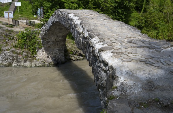 Old stone bridge spanning a river in green surroundings, Makhuntseti stone arch bridge, Adjaristskali river, Adjara, Adjaria, Lesser Caucasus, Georgia