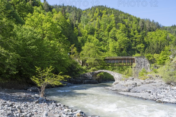 River flows under a car and stone bridge amidst green forests, Purtio stone arch bridge, Adjaristskali river, Adjara, Adjaria, Lesser Caucasus, Georgia