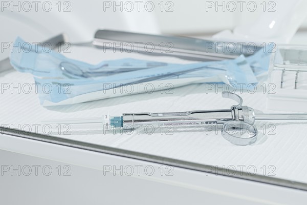 A carpal syringe, reusable, for use in dentistry, for the administration of anesthetic, lies on the table