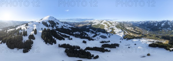 Wonderful winter landscape with Hohe Salve, blue sky and snow, mountains and mountain valley, aerial view of Skiwelt Wilder Kaiser ski area, Brixental, Tyrol, Austria