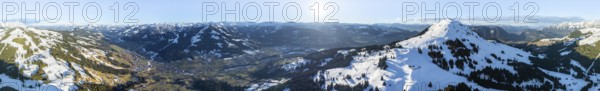 Alpine panorama, fantastic winter landscape with Hohe Salve, blue sky and snow, mountains and mountain valley, aerial view Skiwelt Wilder Kaiser ski area, Brixental, Tyrol, Austria