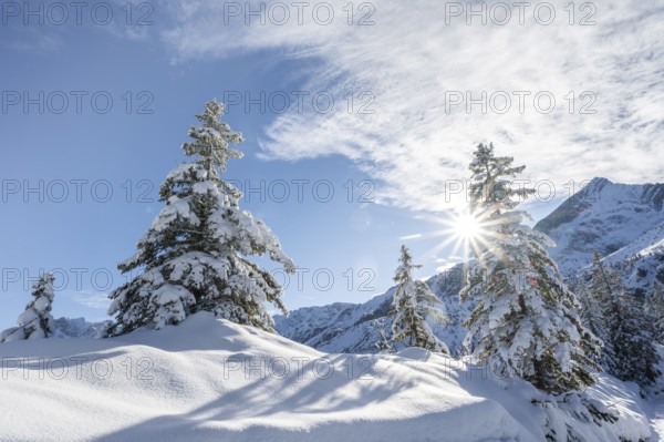 View of snowy mountain landscape with Alpspitz mountain peak, with sun star, ascent to Längenfelderkopf, Wetterstein Mountains, Garmisch-Partenkirchen, Bavaria, Germany