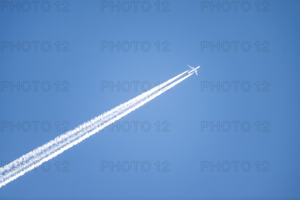 Airplane against blue sky with kondes strips, Tyrol, Austria