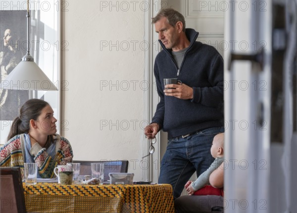 Home office, father and daughter working at the breakfast table, grandchild on the right, Mecklenburg-Western Pomerania, Germany