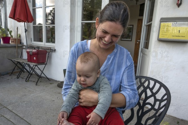 Young mother with her baby on her lap, Mecklenburg-Western Pomerania, Germany
