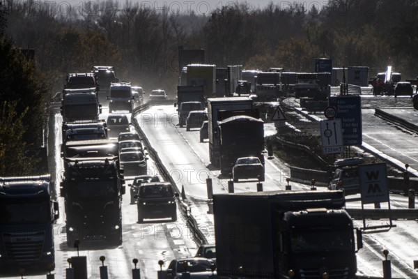 Highway construction site, the A57 is extended to 6 lanes on the section between the Meerbusch motorway junction and the Oppum junction, traffic runs parallel to 2 narrowed lanes, wet road after rain shower, Krefeld, North Rhine-Westphalia, Germany