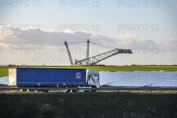 86.5 MW peak open space photovoltaic systems, from RWE, with over 141, 000 solar modules, on a side strip, along the A44 motorway near Jüchen, on the timber triangle, recultivated open-cast mining site, excavator in the Garzweiler lignite mine, North Rhine-Westphalia, Germany