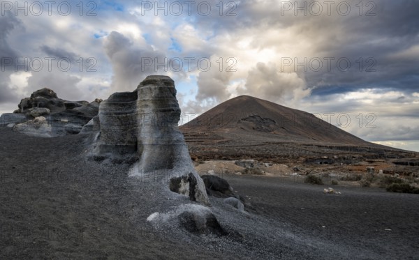 Eroded rock formations, volcanic landscape with dramatic cloudy skies, Ciudad Estratificada or Los Roferos, Antigua Rofera de Teseguite, Lanzarote, Canary Islands, Spain