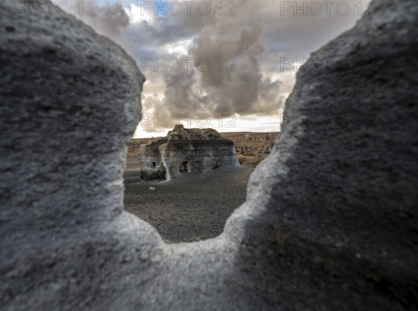 Eroded rock formations, volcanic landscape with dramatic cloudy sky at sunset, Ciudad Estratificada or Los Roferos, Antigua Rofera de Teseguite, Lanzarote, Canary Islands, Spain