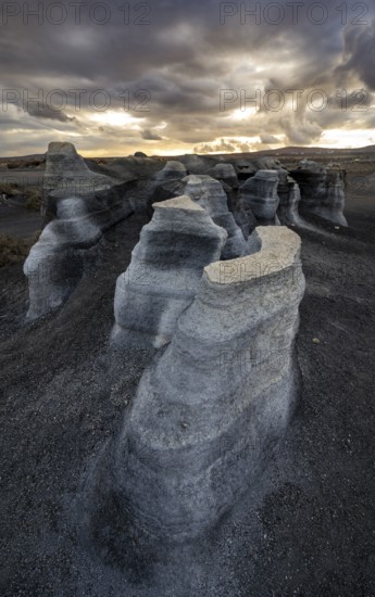 Eroded rock formations, volcanic landscape with dramatic cloudy sky at sunset, Ciudad Estratificada or Los Roferos, Antigua Rofera de Teseguite, Lanzarote, Canary Islands, Spain