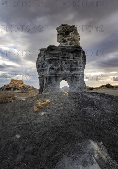 Eroded rock formations with rock tunnels, volcanic landscape with dramatic cloudy skies, Ciudad Estratificada or Los Roferos, Antigua Rofera de Teseguite, Lanzarote, Canary Islands, Spain
