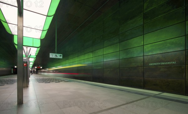 HafenCity University underground station, illuminated in color, green, underground train, motion effect, long exposure, light trails, U4, travelers, platform, stop, train station, subway, sign, boarding area wheelchair user, stroller, public transport, HVV, Hamburger Verkehrsverbund, public transport, public transport, Free and Hanseatic City of Hamburg, Germany