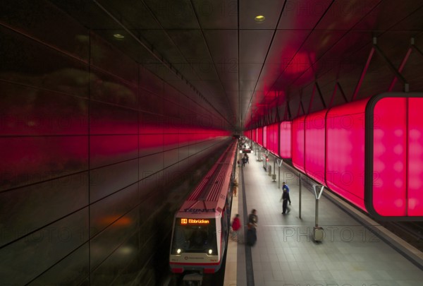 HafenCity University underground station, illuminated in color, red, underground train, U4, travelers, platform, stop, train station, subway, public transport, HVV, Hamburger Verkehrsverbund, Hochbahn, local transport, Free and Hanseatic City of Hamburg, Germany