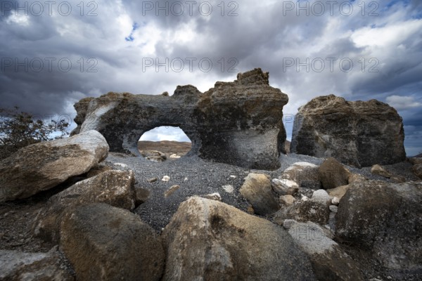 Eroded rock formations with rock tunnels, volcanic landscape with dramatic cloudy skies, Ciudad Estratificada or Los Roferos, Antigua Rofera de Teseguite, Lanzarote, Canary Islands, Spain