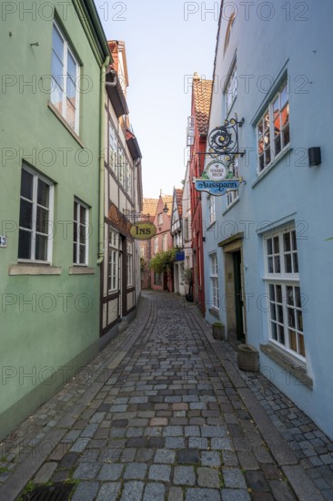 Colourful houses with shops and half-timbered houses in a small alley, picturesque district with nice little houses, Schnoor quarter in the morning light, Bremen, Germany