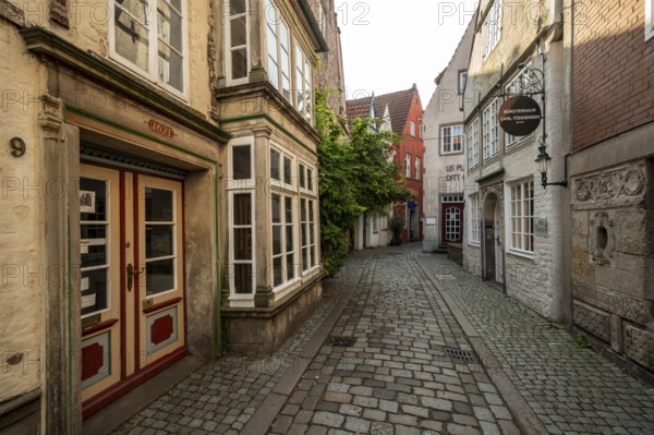 Colourful houses with shops and half-timbered houses in a small alley, picturesque district with nice little houses, Schnoor quarter in the morning light, Bremen, Germany