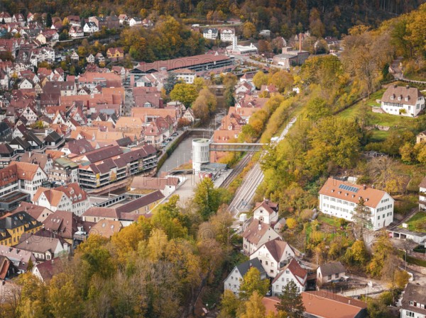 Wide angle view of the city with densely packed roofs and autumn trees in the area, Calw, Black Forest, Germany