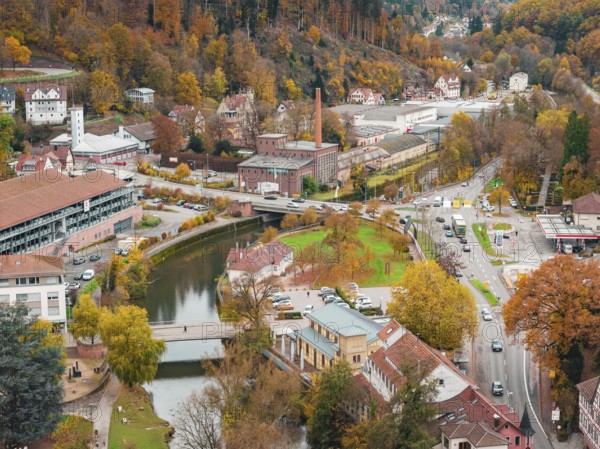 City view with river and bridges in autumn color scheme, surrounded by trees and roads, Calw, Black Forest, Germany
