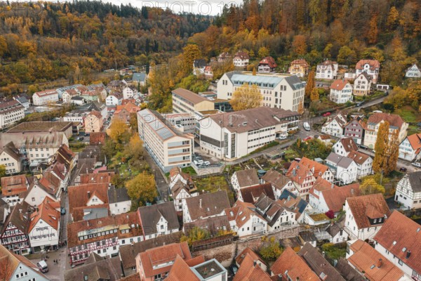 Overview of a town with half-timbered houses and modern buildings in an autumn mountain landscape, Calw, Black Forest, Germany