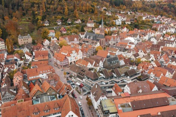 Aerial view of a historic old town with reddish brown roofs and half-timbered houses in autumn, Calw, Black Forest, Germany