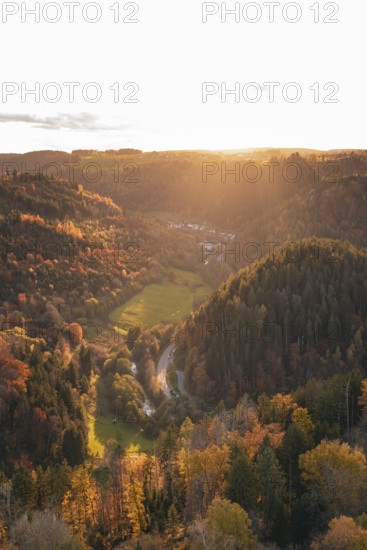 Sunset illuminates a valley with dense forests and a river course in autumn, Calw, Black Forest, Germany