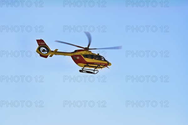 Helicopter flying against a blue sky, alpine rescue, mountain rescue, Chamonix, Haute-Savoie, France