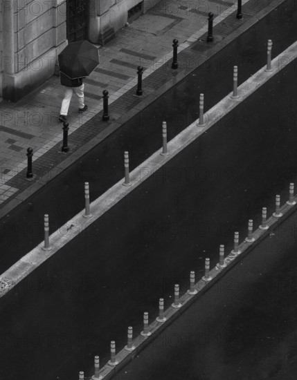 Man with umbrella walking on a street, from above, monochrome, street scene, Belgrade, Serbia