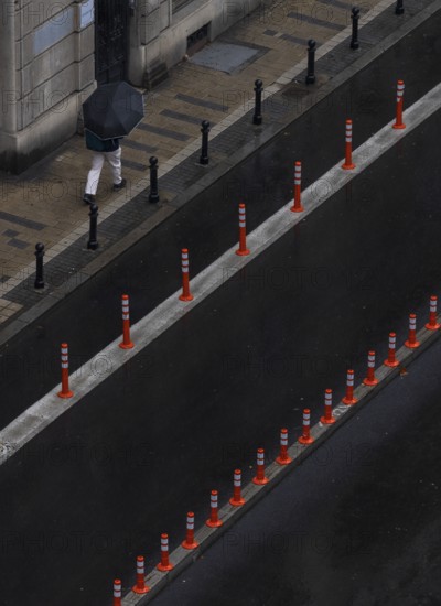 Man with umbrella walking on a street, from above, street scene, Belgrade, Serbia