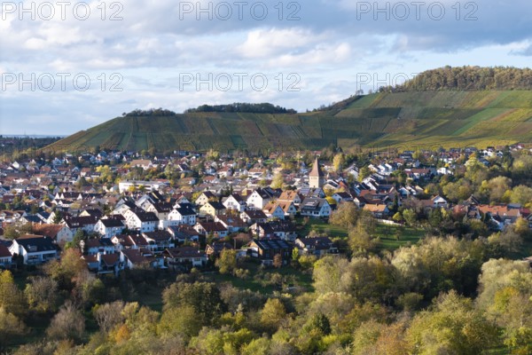 View of a village with church between vineyards and hills under a cloudy sky, autumn, Korb-Steinreinach im Remstal, Baden-Württemberg, Germany