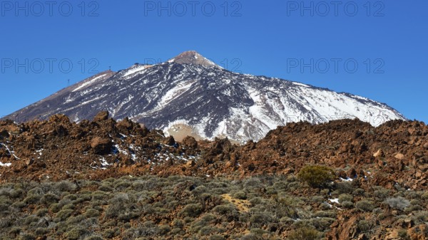 Snow-capped Teide volcano against barren rocky landscape under clear sky, UNESCO World Heritage Site, Teide National Park, Tenerife, Canary Islands, Spain