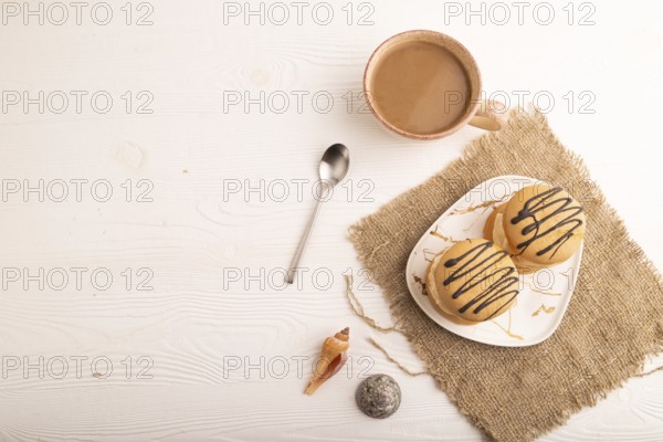 Caramel Cream Cakes on white wooden background and linen textile, cup of coffee, top view, flat lay, copy space