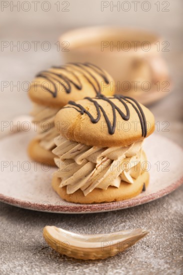 Caramel Cream Cakes on brown concrete background, cup of coffee, side view, close up, selective focus