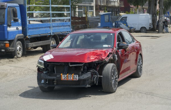 Close-up of red car with frontal damage on the road, Georgia