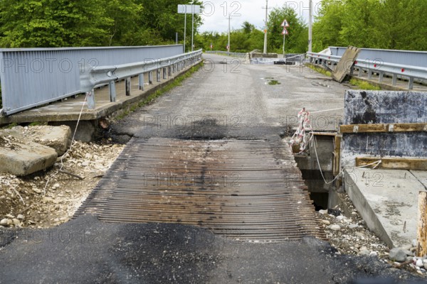 Damaged bridge with metal mesh and surrounding construction in a green area, bridge over the Techuri River, Nokalakevi, Mingrelia region and Upper Svaneti, Georgia