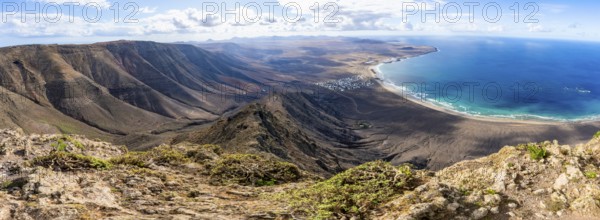 Panorama at Castillejo viewpoint, view from the Risco de Famara cliffs to the coast and the sea with Famara beach, Playa de Famara with La Calaeta, Lanzarote, Canary Islands, Spain