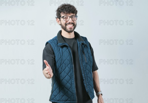 Friendly handsome guy greets you with open hand isolated. Male person extending her hand to the camera welcoming you