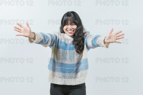 Friendly asian girl welcoming with open arms isolated. Beautiful asian woman welcoming you with open arms