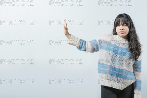 Asian girl making rejection gesture with palm of hand isolated. Displeased asian woman rejecting with palm hand