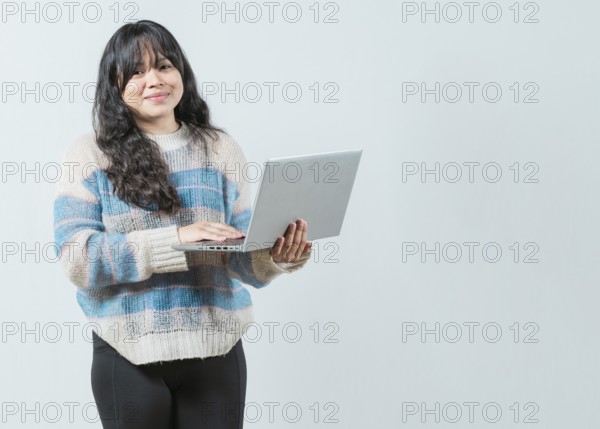 Smiling asian woman using notebook and looking at camera with copy space. Beautiful asian girl using laptop and looking at camera