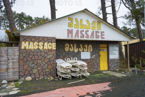 Colourful building with massage signs and stacked loungers outside, beach massage equipment with magnetic sand, magnetite, ureki, Guria region, Georgia