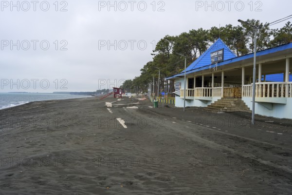 Promenade with buildings and trees along a cloudy beach, beach with magnetic sand, magnetite, Ureki, Guria region, Georgia