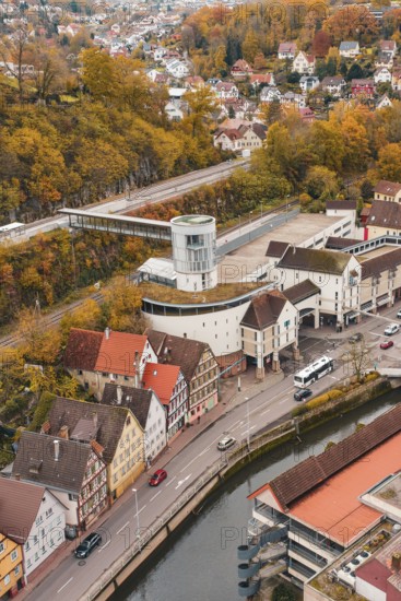 Aerial view of a city with colorful autumn leaves, river and central tower building, Hermann Hessebahn, ZOB Calw, Germany