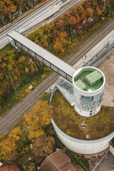 Aerial view of an observation tower with bridge over railroad tracks, surrounded by autumn leaves, Hermann Hessebahn, ZOB Calw, Germany
