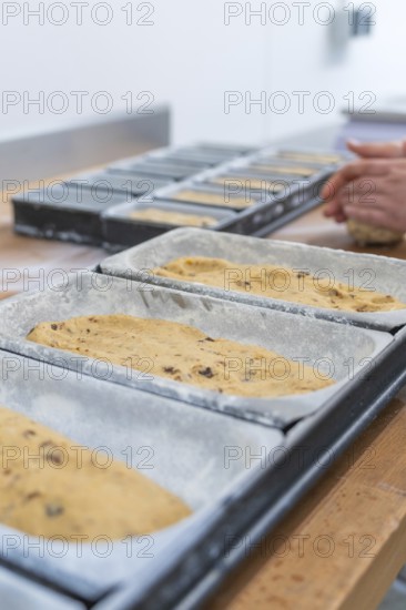 Close-up of dough in loaf pans, hands of a baker visible in the background, Christmas baking, Haselstaller Hof, Wildberg, Germany