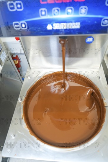 Liquid chocolate is poured into a large container in a machine, Weihnachtsbacken, Haselstaller Hof, Wildberg, Germany