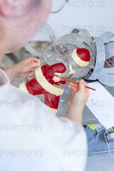 Person paints a plastic mold with red and white as part of a Christmas decoration, Christmas baking, Haselstaller Hof, Wildberg, Germany